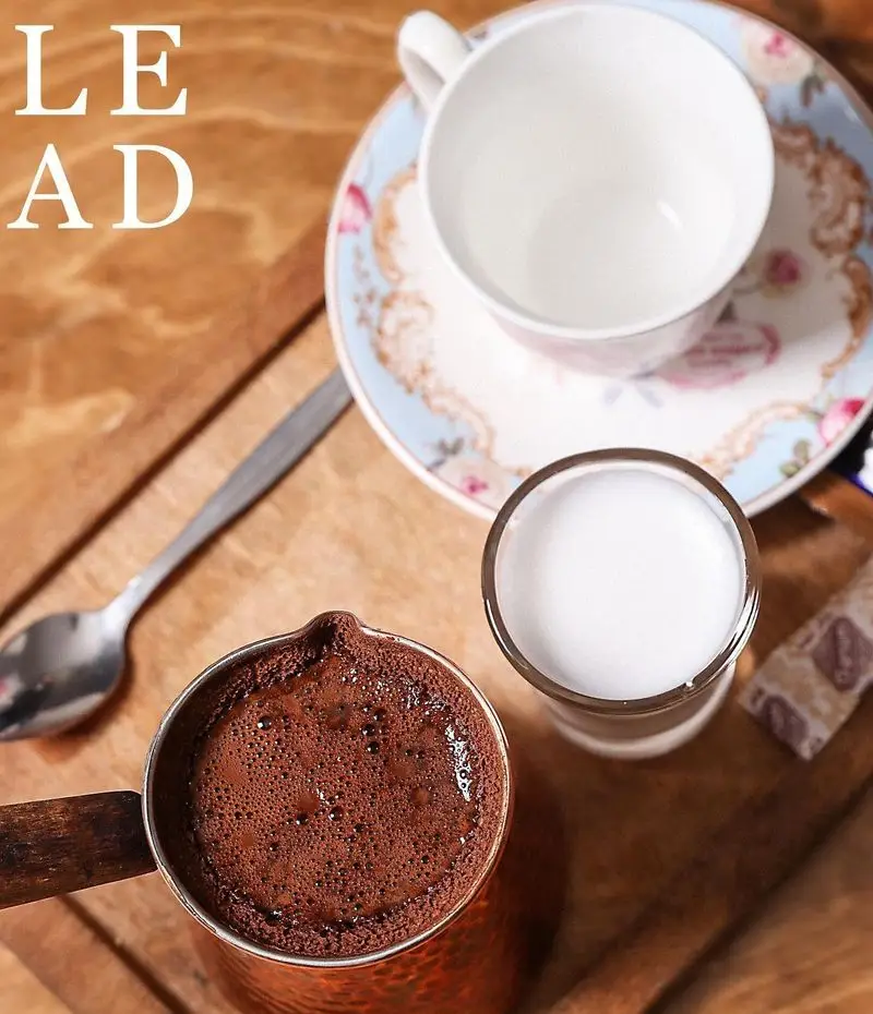 قهوه ترک اصیل و تازه دم کافه لید در ظرف مسی، همراه با شیر و فنجان شیک. تجربه‌ای دلنشین از نوشیدنی گرم و با کیفیت.