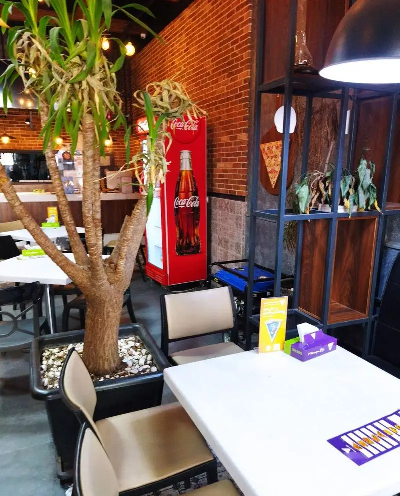 فضای داخلی دنج و دلنشین پیتزا سیب ۳۶۰، با دکوراسیونی جذاب و میز و صندلی‌های راحت، آماده پذیرایی از مشتریان عزیز.