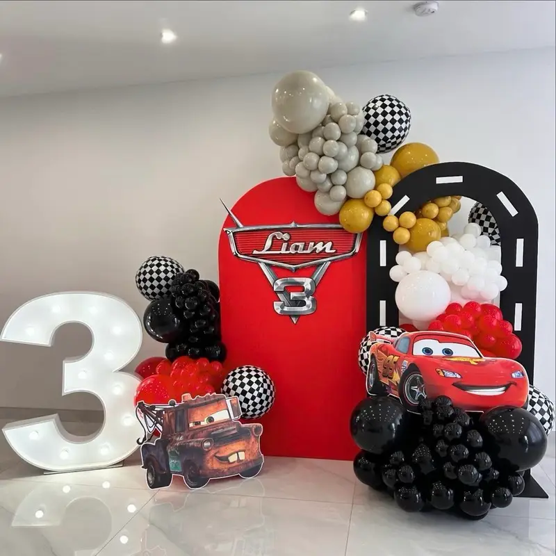 دکور تولد سه سالگی پسرانه با تم محبوب ماشین‌ها، شامل عدد 3 نورانی، بالون آرایی خاص و فیگورهای لایتنینگ مک‌کوئین و میتر.