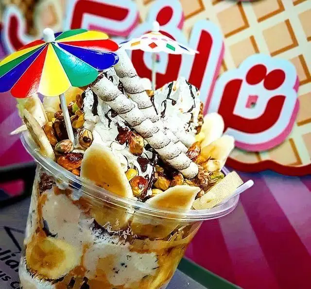 تصویر ویتامینه بستنی لئون ترافیک: دسری لذیذ در لیوان با تزئین خامه، موز، آجیل‌های میکس و ویفر. انتخابی خاص برای لحظات شیرین.