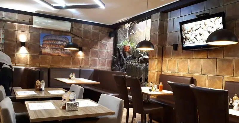 فضای داخلی جذاب و شیک رستوران آروما، با چیدمان دلنشین میز و صندلی‌های راحت و دکوراسیون الهام گرفته از رم باستان.