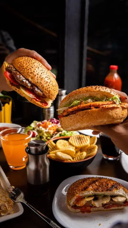 تصویری جذاب از منوی کافه گریل ببک شامل برگر دست‌ساز، ساندویچ مرغ، سیب‌زمینی سرخ کرده و سالاد تازه در فضای دلنشین.