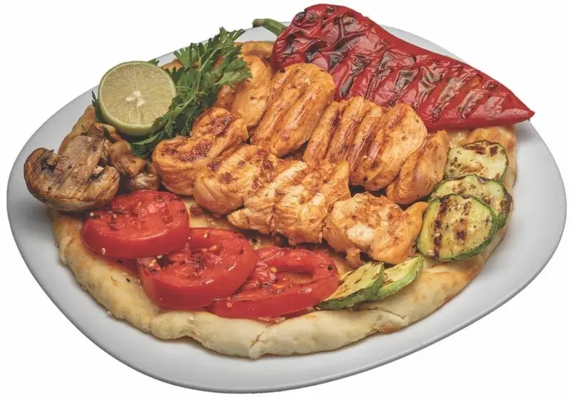 جوجه کباب گریل شده به همراه سبزیجات کبابی (فلفل دلمه، کدو، گوجه و قارچ) روی نان در کافه گریل ببک، غذای سالم و رژیمی.