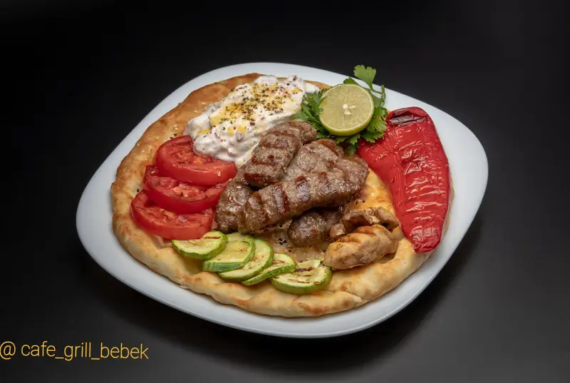 بشقاب کامل کوفته کباب گریل شده همراه نان، فلفل، کدو، گوجه فرنگی، قارچ و سس ماست در کافه گریل ببک.