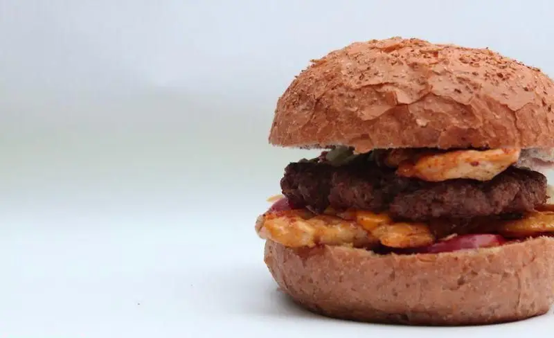 برگر دوبل خوشمزه فست فود کافی 72 با نان برشته، پتی گوشت و مرغ، سس مخصوص و مخلفات تازه برای تجربه‌ای بی‌نظیر.