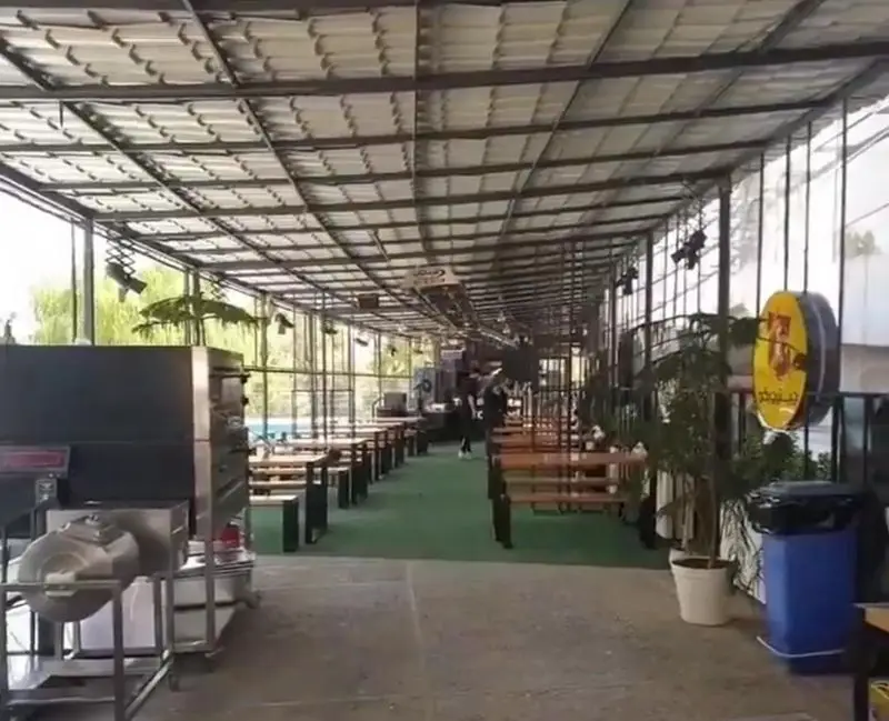 نمایی از فضای وسیع و سرپوشیده رستوران کی اف سی سوگود ولیعصر، با چیدمان میز و صندلی و تجهیزات آشپزخانه مدرن برای تجربه غذایی لذت‌بخش.