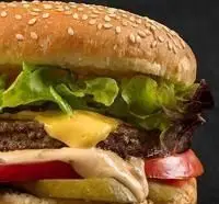 تصویر یک همبرگر دوبل پنیر با کاهو، گوجه، خیارشور و سس ویژه پیتزا شیلا پیروزی. بهترین طعم فست فود در رستوران پیروزی.