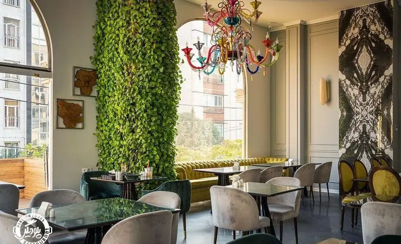 فضای داخلی دلباز و مدرن رستوران پلو دیگی با دیوار سبز طبیعی چشم‌نواز، لوستر شیشه‌ای رنگارنگ، مبلمان مخملی و چیدمان میزهای غذا.