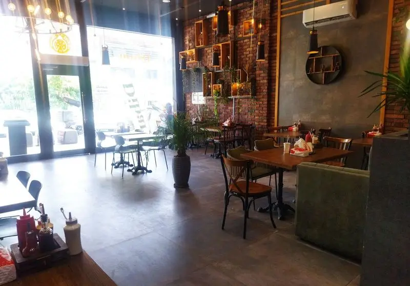 نمای داخلی کافه رستوران ایتالیایی دیبارو، با دکوراسیون آجری گرم، فضای دنج و میز و صندلی‌های چوبی آماده پذیرایی.