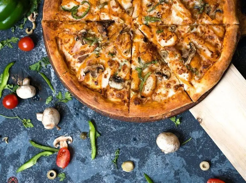 پیتزا مرغ و قارچ پرملات و آبدار دیبارو با تکه های فلفل سبز و پنیر فراوان در کافه رستوران ایتالیایی دیبارو.