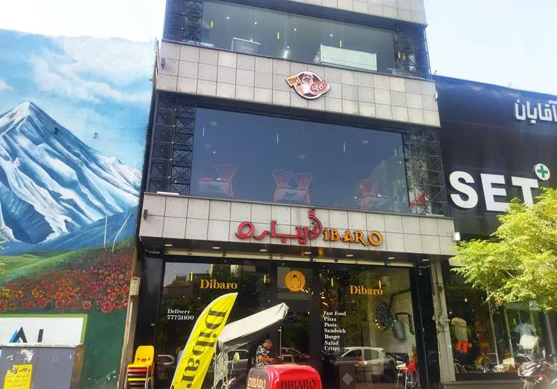 نمای بیرونی کافه رستوران ایتالیایی دیبارو Dibaro، با تابلو و لوگوی سرآشپز پیتزا. ارائه فست فود، پیتزا و پاستا با دلیوری.