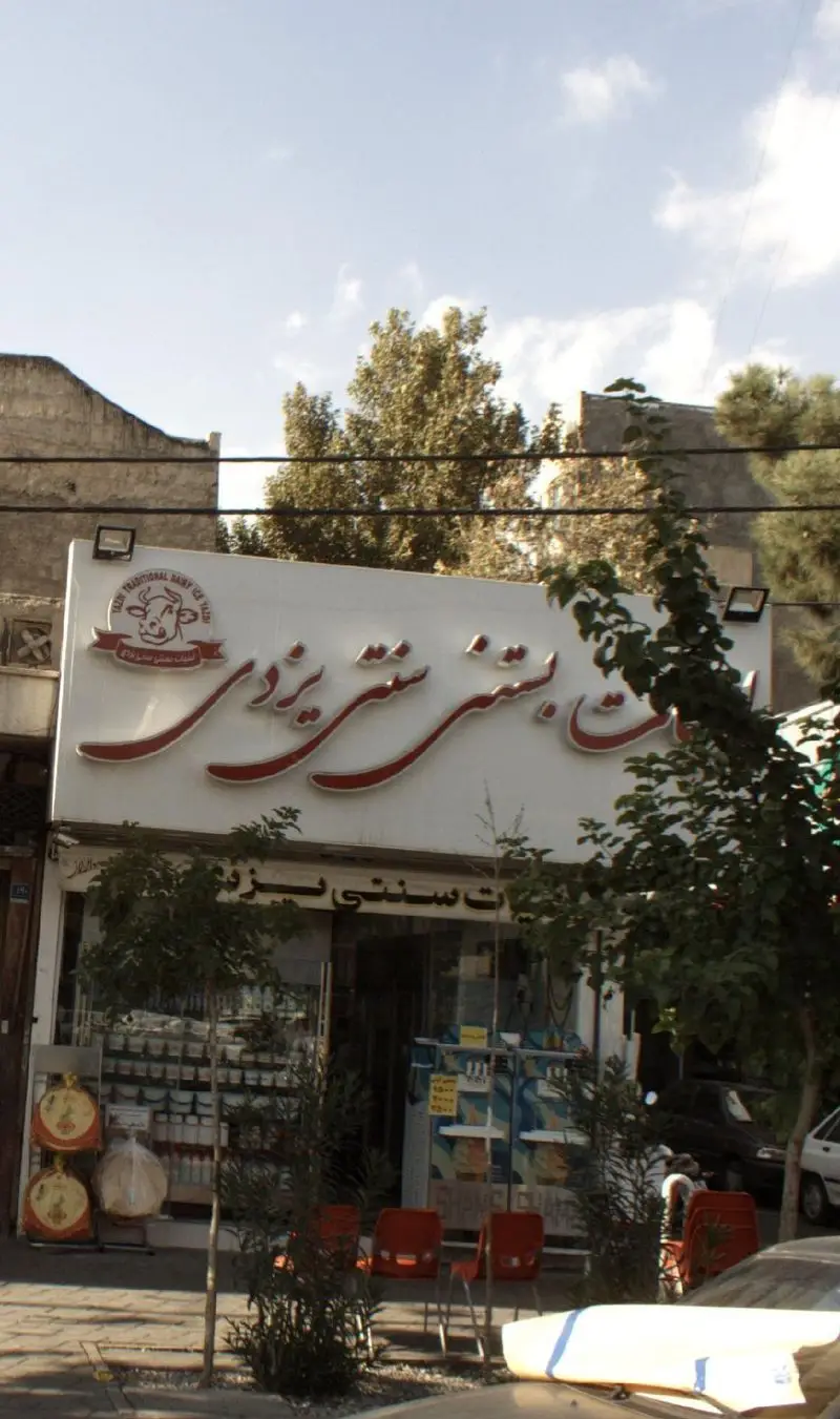 نمای بیرونی فروشگاه لبنیات بستنی سنتی یزدی، با تابلوی بزرگ و لوگوی گاو. ارائه دهنده محصولات لبنی تازه و بستنی سنتی خوشمزه یزدی.