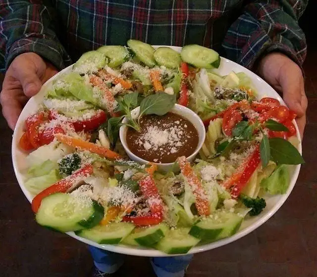 سالاد سبزیجات تازه و رنگارنگ فست فود ایوان شامل کاهو، خیار، گوجه، فلفل دلمه‌ای، هویج، سس مخصوص و پنیر پارمزان.