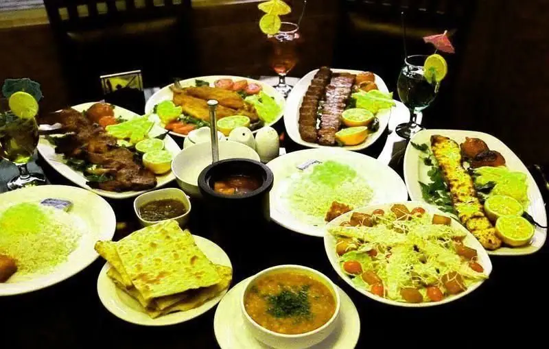 میز شام مجلل ایرانی در رستوران محفل با انواع کباب، ماهی، برنج سفید و سبز، سالاد سزار، سوپ و نان تازه. بهترین طعم‌های سنتی.