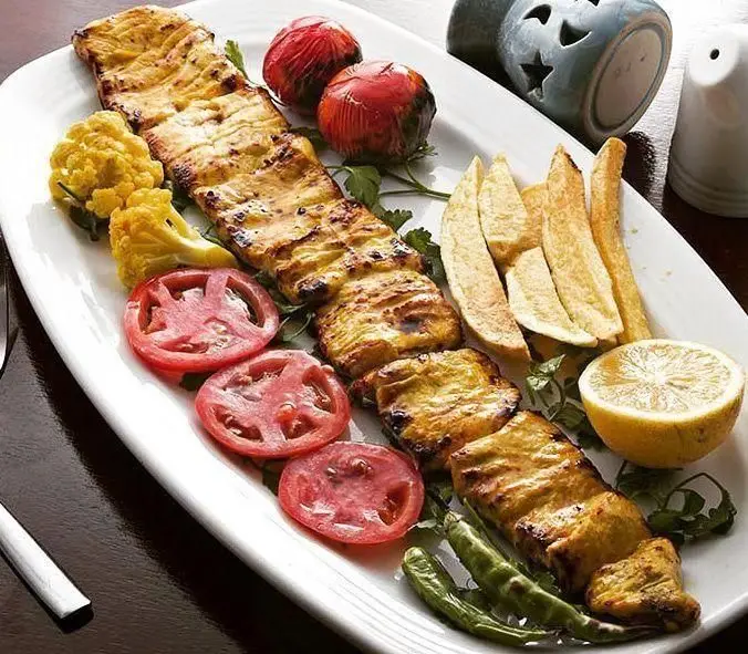 کباب جوجه زعفرانی رستوران ایرانی محفل با مخلفاتی چون گوجه کبابی، گوجه تازه، سیب‌زمینی، لیمو، فلفل سبز و گل کلم، یک غذای اصیل.