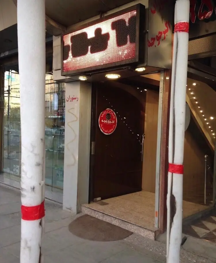 نمای بیرونی رستوران اکبر جوجه با تابلوی LED و خوش آمدید، ورودی اصلی و دکوراسیون گرم و دعوت‌کننده برای مشتریان.