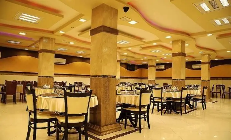 سالن غذاخوری بزرگ و دلباز رستوران اکبر جوجه با دکوراسیون شیک، میزهای گرد چیده شده و صندلی‌های راحت، آماده پذیرایی از مشتریان.