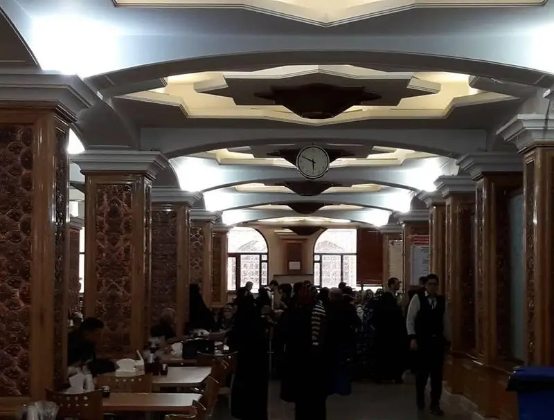 رستوران حرم حضرت عبدالعظیم، فضایی دلباز و زیبا با ستون‌های نفیس و سقف مزین، میزبان زائران گرامی در محیطی آرام و دلنشین.