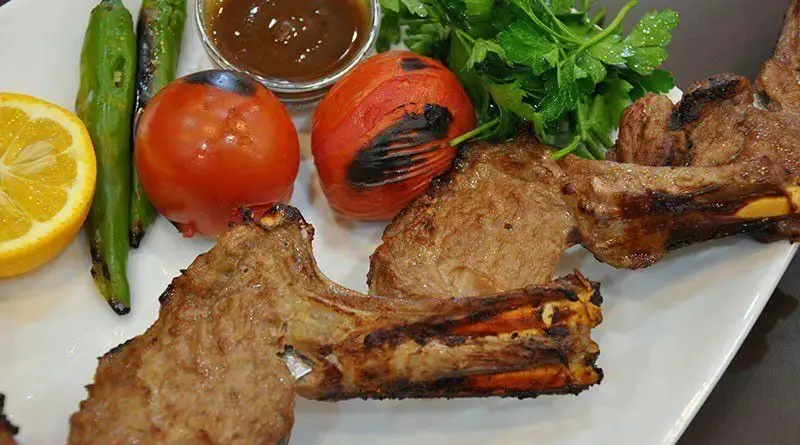 دنده کباب ویژه شمرون کباب به همراه گوجه و فلفل کبابی، لیمو و جعفری تازه؛ طعم بی‌نظیر غذای سنتی و لذیذ ایرانی.