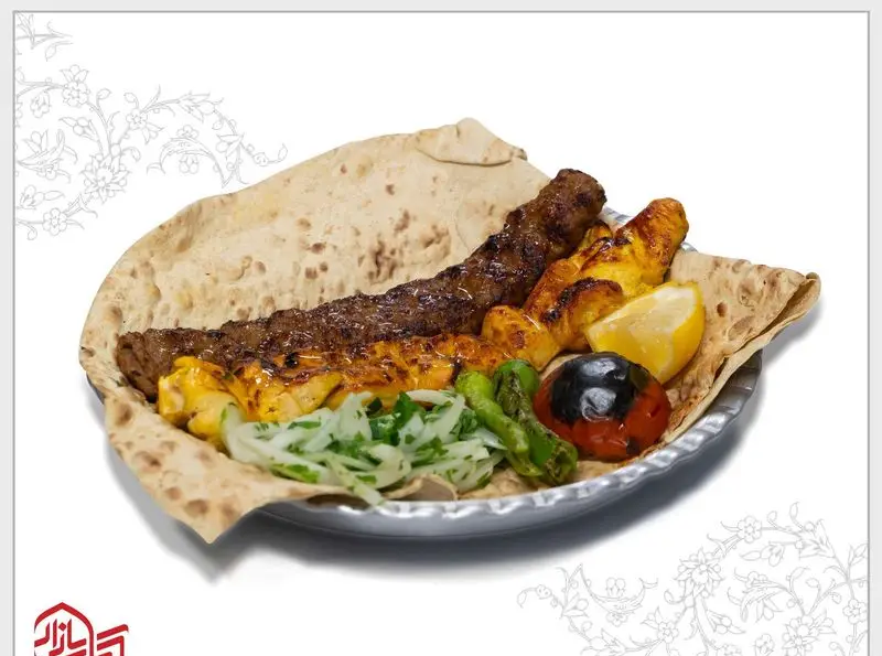 سینی کباب بازار با کوبیده، جوجه کباب، نان داغ، گوجه و فلفل کبابی. تجربه‌ای خوشمزه از کباب اصیل ایرانی در رستوران کباب بازار.