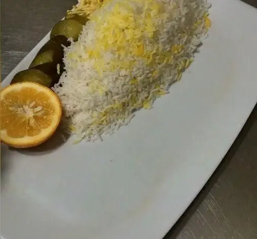 پلو زعفرانی و چلو سفید غنچه، سرو شده با نارنج تازه و ترشی خیار، طعمی از غذای اصیل و دلنشین ایرانی.