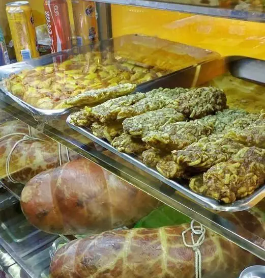 نمایی از یخچال ساندویچ مقدم با انواع غذای آماده و فست فود شامل کوکو، سیب زمینی و کالباس‌های تازه به همراه نوشیدنی‌های متنوع.