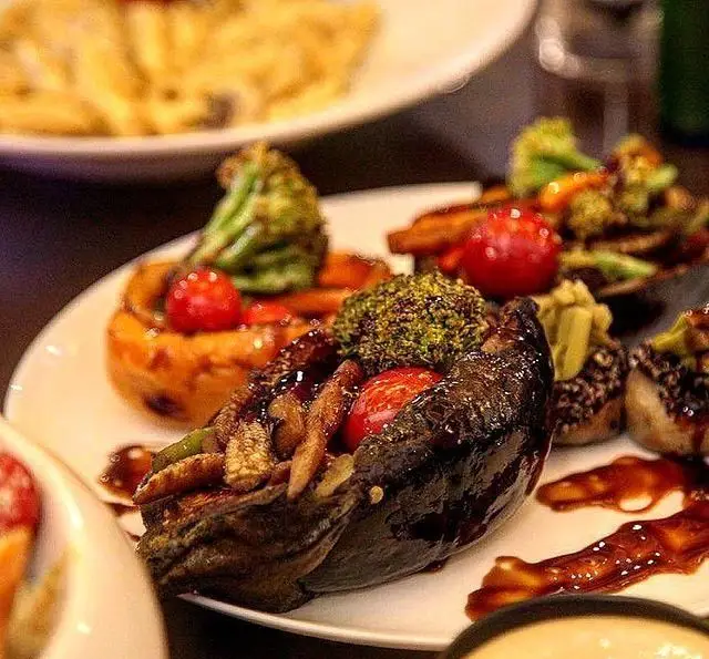 بادمجان شکم پر، بروکلی و گوجه گیلاسی با سبزیجات برشته و سس مخصوص، سرو شده در کافه رستوران موخو لانژ.