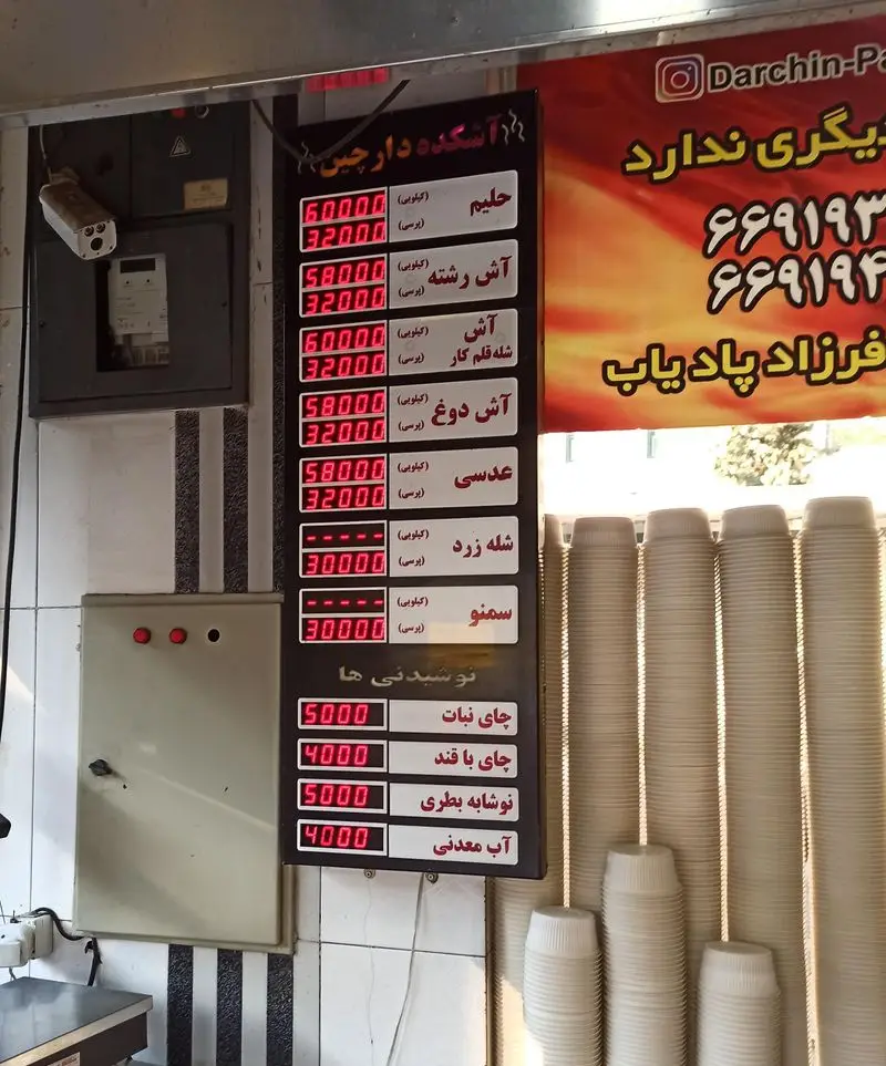 تابلوی منو و قیمت‌های آش و حلیم دارچین شامل حلیم، آش رشته، آش شله قلم‌کار، آش دوغ، عدسی، شله‌زرد، سمنو و نوشیدنی‌ها.