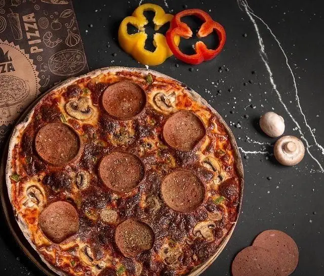 بهترین پیتزا پپرونی و قارچ کافه دیدارو، تهیه شده با تازه ترین مواد روی میز تیره؛ انتخابی عالی برای دوستداران غذا.