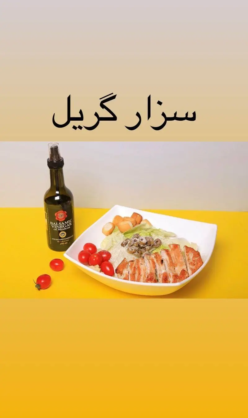 تصویری از سالاد سزار گریل کافه دیدارو با تکه‌های مرغ گریل شده، گوجه گیلاسی تازه، نان کروتون و سرکه بالزامیک.