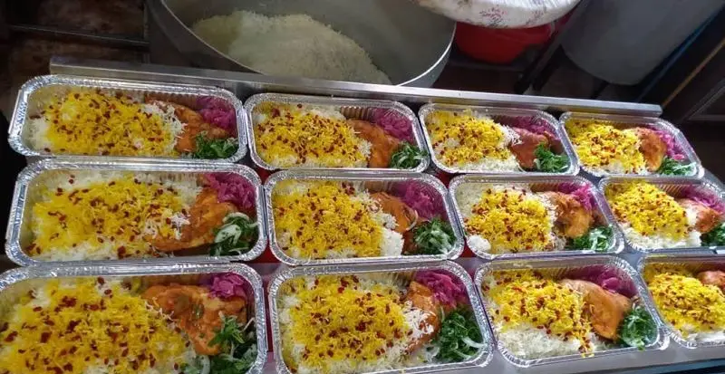تصویری از آماده‌سازی و بسته‌بندی زرشک پلو با مرغ توسط تهیه غذای شرکتی پارسی آنیسا شعبه یادگار در ظروف آلومینیومی.