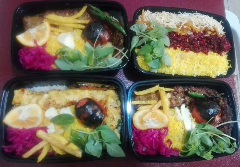 چهار پرس غذای ایرانی شامل انواع کباب (کوبیده، جوجه) همراه با برنج قالبی، سیب‌زمینی، گوجه کبابی و مخلفات تازه از تهیه غذای شرکتی پارسی آنیسا شعبه یادگار.