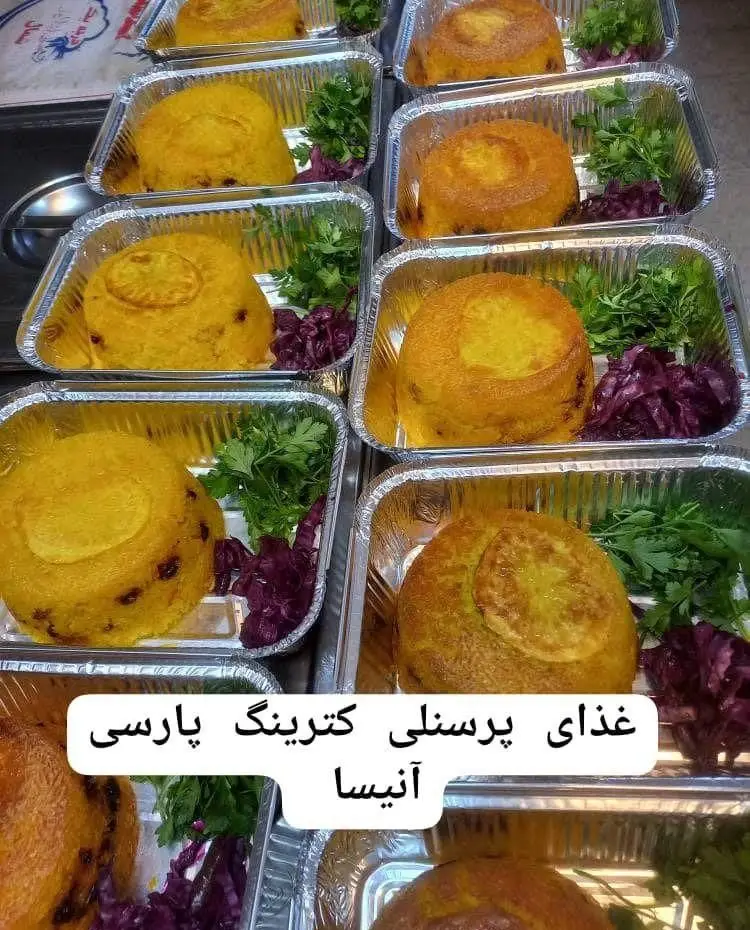 تهیه غذای شرکتی پارسی آنیسا شعبه یادگار: تصویر چندین پرس غذای ایرانی زعفرانی (ته‌چین) با سبزی و کلم قرمز در ظروف آلومینیومی آماده سرو.