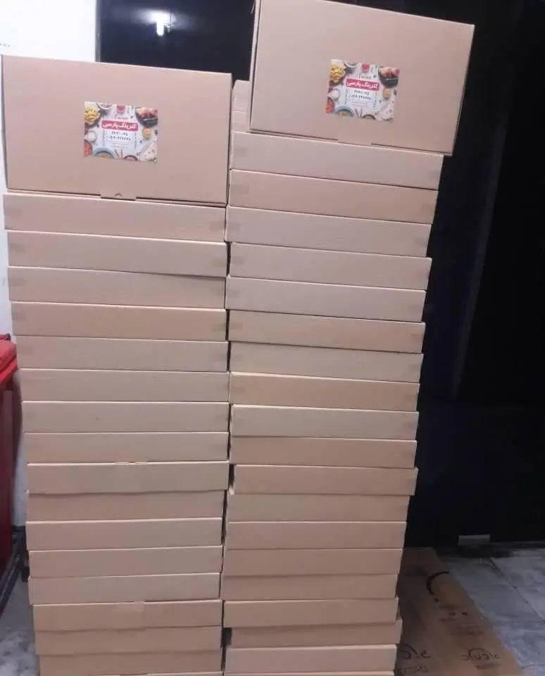 مجموعه‌ای بزرگ از جعبه‌های بسته‌بندی غذا، آماده توزیع توسط تهیه غذای شرکتی پارسی آنیسا شعبه یادگار برای سفارشات انبوه.