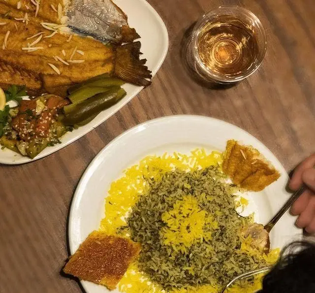 تصویری جذاب از سبزی پلو با ماهی تازه و ته دیگ طلایی در رستوران بین المللی ۱۳۳، بهترین گزینه برای ناهار یا شام اصیل ایرانی.