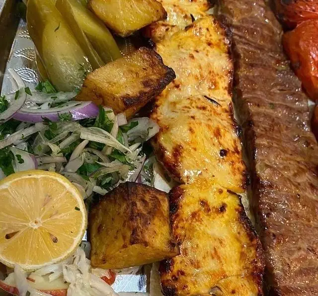 کباب کوبیده و جوجه کباب زعفرانی با سیب زمینی، گوجه کبابی، پیاز و جعفری، لیمو و ترشی از کافه رستوران پاشا.