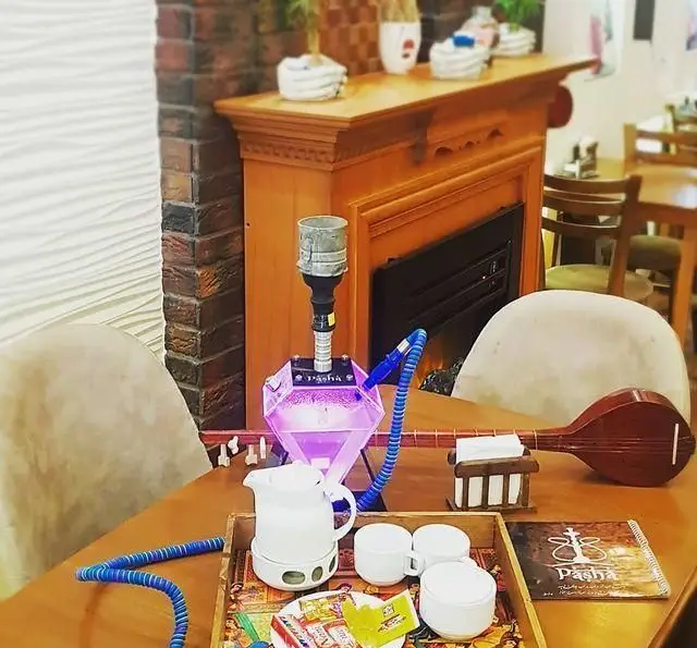 کافه رستوران پاشا: لذت نوشیدنی‌های گرم و قلیان مدرن با نورپردازی بنفش، در فضایی گرم و دلنشین کنار شومینه و ساز سنتی.