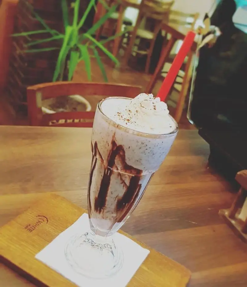 میلکشیک لذیذ با خامه و سس شکلات در کافه رستوران پاشا، مناسب برای استراحت و لذت بردن از نوشیدنی‌های خنک در محیطی دلنشین.