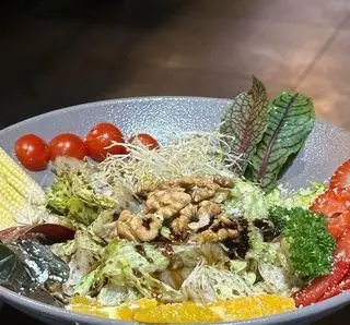 بشقاب سالاد رنگارنگ و تازه کافه رستوران راکان با ترکیبات لذیذ شامل کاهو، گوجه، توت فرنگی، گردو و بروکلی. یک انتخاب سالم.
