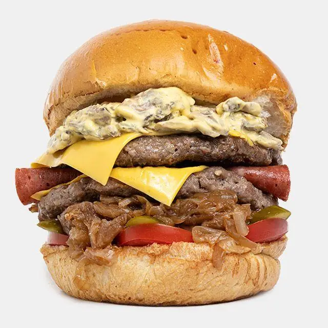 تصویر ماکرو از برگر خاص و بزرگ باروس برگر: برگر چندلایه با پنیر، سس خامه ای قارچ، پیاز کاراملی و تکه های هات داگ.