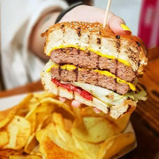 همبرگر دوبل پنیردار بریده شده باروس برگر با دو لایه پتی گوشت، کاهو، گوجه و سیب‌زمینی چیپسی. غذایی دلپذیر از فست‌فود