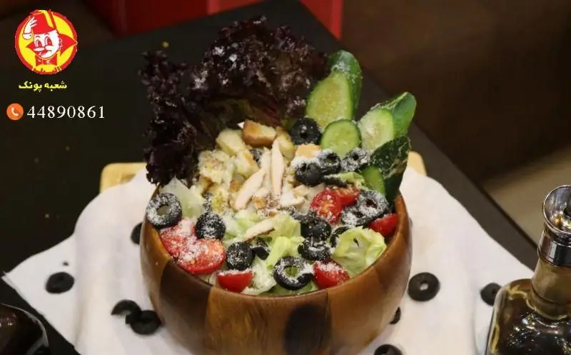 تصویری از سالاد سزار لذیذ رستوران البیک شعبه پونک با مرغ تازه، کاهو، کروتون، زیتون و پنیر، غذایی سالم و مقوی.
