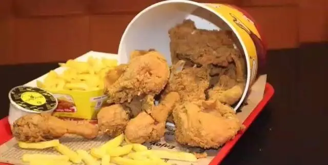 یک سطل بزرگ مرغ سوخاری ترد و طلایی رنگ رستوران البیک، با سیب زمینی سرخ کرده فراوان و سس مخصوص، آماده سرو.