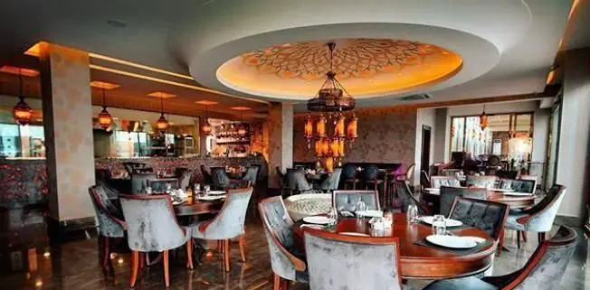 فضای داخلی شیک و لوکس رستوران لبنانی باب البحر با دکوراسیون مدرن و سنتی، میزهای چیده شده و لوستر جذاب برای تجربه غذای دلپذیر.