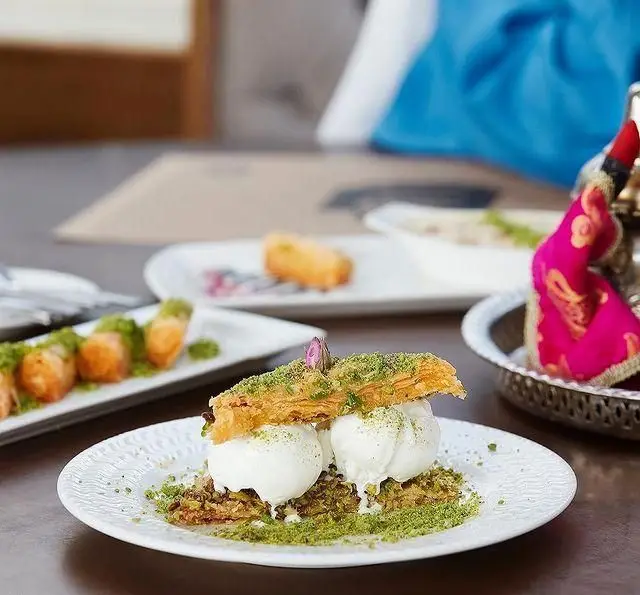 دسرهای سنتی و خوشمزه رستوران لبنانی باب البحر: باقلوای ترد با بستنی و پسته آسیاب شده، گزینه‌ای عالی برای شیرین‌کام شدن.