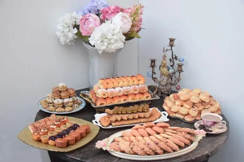 میز شیک و پر از انواع شیرینی، کوکی و دسرهای خوشمزه و تازه از شیرینی لادن طلایی، مناسب برای پذیرایی خاص.