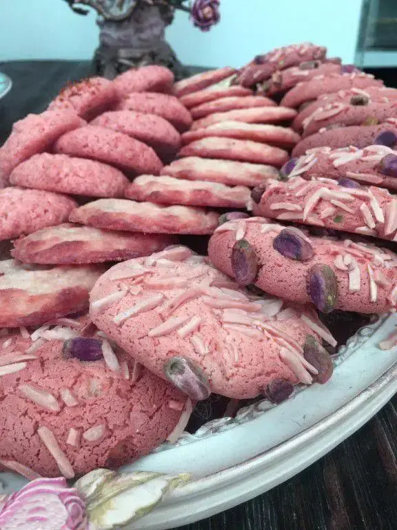 مجموعه متنوع شیرینی‌های صورتی خاص لادن طلایی، مزین به پسته و بادام، ایده‌آل برای جشن‌ها و پذیرایی‌های شما.