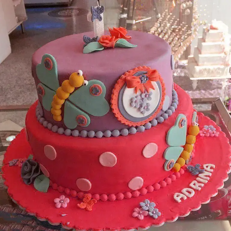 کیک تولد دخترانه دو طبقه با تم پروانه و کرم ابریشم از شیرینی لادن طلایی مناسب جشن تولد یک سالگی آدرینا.