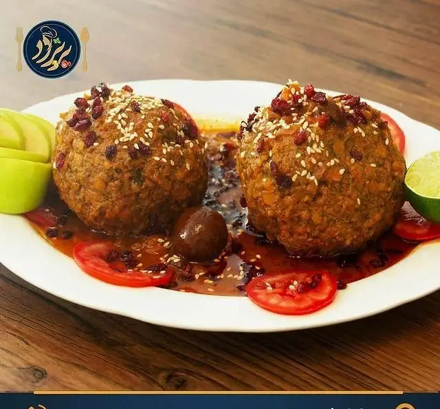 کوفته تبریزی خوشمزه و مجلل رستوران کترینگ پریزاد، تزئین شده با زرشک و کنجد، همراه با چاشنی‌های تازه. غذای اصیل ایرانی.