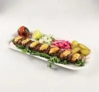کباب کوبیده زعفرانی و مجلسی باغچه رستوران ونوس شهران با سس مخصوص، گوجه کبابی، لیمو و سبزیجات تازه، یک غذای سنتی لذیذ.